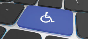 closeup of a computer keyboard, with large key at center with the International Symbol of Access ((International) Wheelchair Symbol)