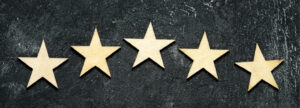 Image of five gold stars arranged in a shallow arc on a black background