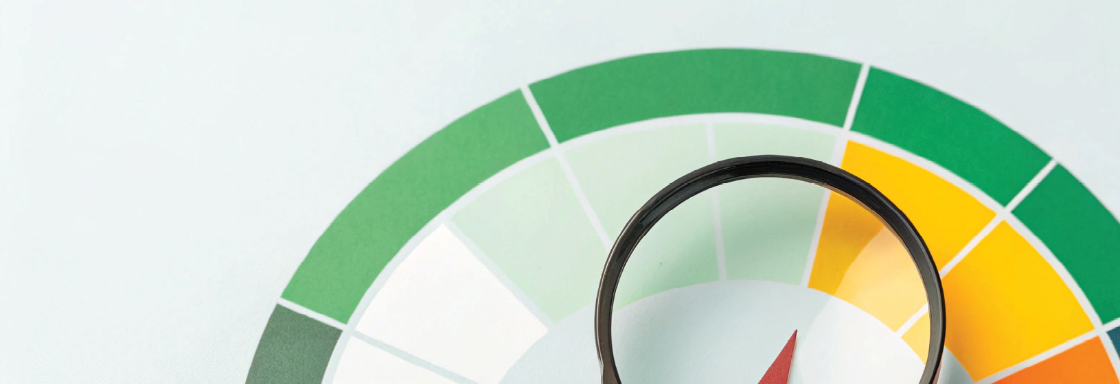 closeup of a colorful scale in an arc shape with colors ranging from white, green, yellow, and orange. Arrow is point slightly right toward the yellow arc band.